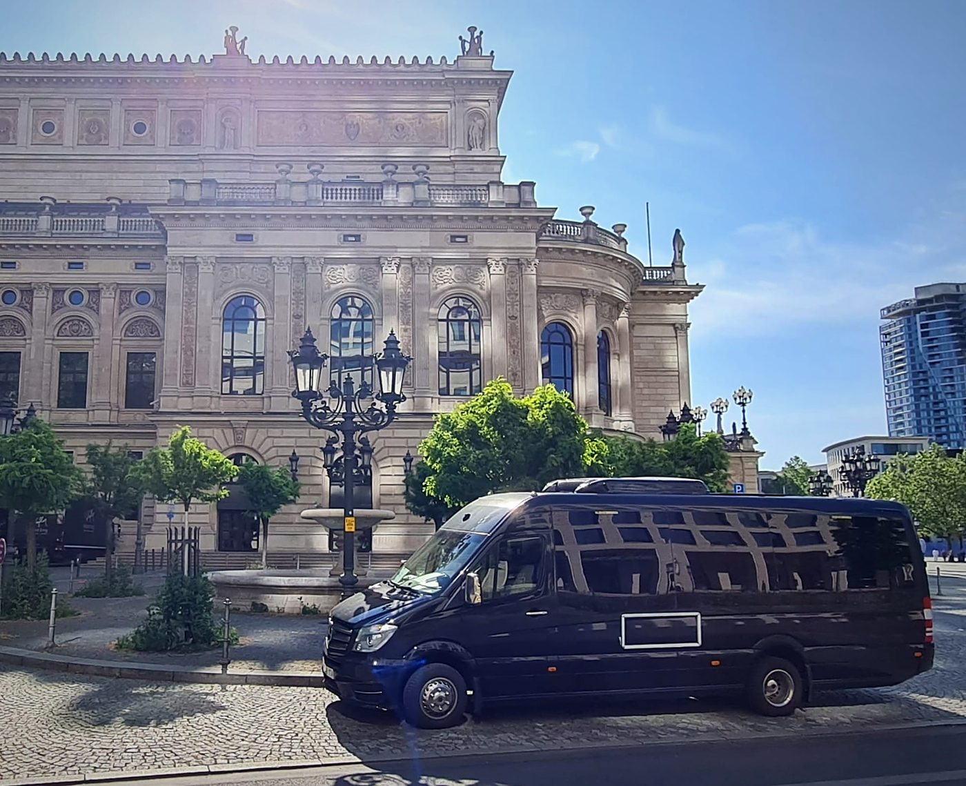 Minibús VIP negro de Kapital Bus ante un edificio monumental